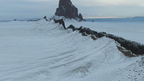 4k-Aerial-reveal-of-Shiprock-Monument-near-New-Mexico,-USA-covered-in-snow