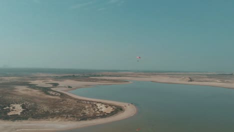 Aerial-View-Of-Motorised-Paraglider-Flying-Over-Salt-Lake-In-Karachi,-Pakistan