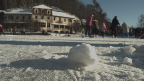 Large-snowball-accumulated-on-snowpath-sideline-from-people-ice-skating-in-Harasov-Frozen-lake,-Kokorin,-Czech-Republic---Medium-ground-level-static-shot