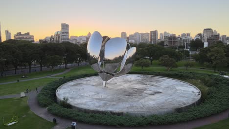 Orbit-of-Floralis-Generica-stainless-steel-sculpture-in-Naciones-Unidas-square-at-golden-hour,-Buenos-Aires