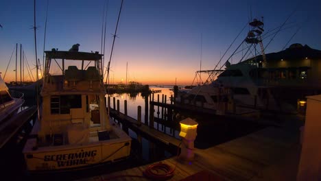 Watching-the-sunset-from-the-pier,-several-cabin-cruisers-are-docked-at-the-pier