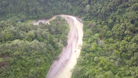 Winding-river-rushing-down-the-Sumatran-tropical-Forest,-Indonesia---Aerial-fly-over-slow-tilt-down-reveal-shot