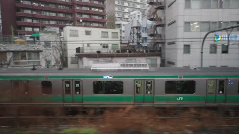 Traveling-Subway-Train-Passing-By-City-Skylines-At-Daytime-In-Tokyo,-Japan