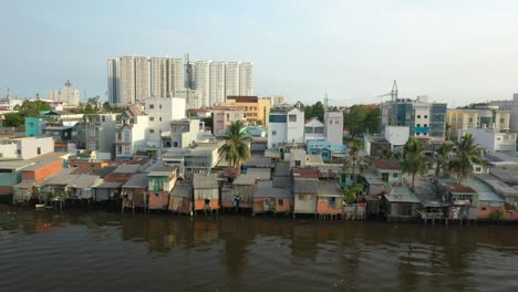 Toma-Clásica-De-Drones-Con-Contraste-De-Edificios-Antiguos-Y-Nuevos-A-Lo-Largo-Del-Paseo-Marítimo-Del-Canal-En-El-Distrito-Ocho-De-La-Ciudad-De-Ho-Chi-Minh,-Vietnam