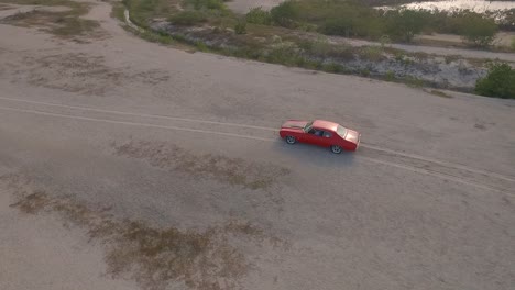Drohnenansicht-Eines-Alten-Amerikanischen-Muskelautos-In-Einer-Wüste-Während-Eines-Sonnenuntergangs