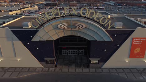 Close-up-reveal-of-Cineplex-Odeon-movie-theatre-cinema-exterior-with-signage-and-vacant-parking-lot