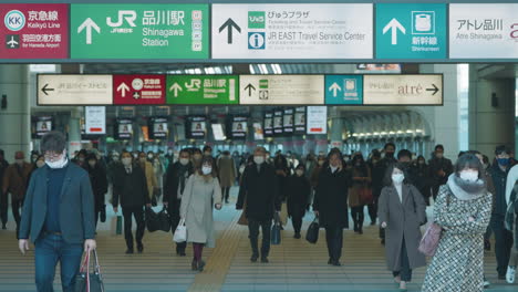 Una-Toma-Fija-De-Personas-Con-Máscaras-Faciales-Que-Viajan-En-La-Estación-De-Shinagawa-Durante-La-Pandemia-En-Tokio,-Japón