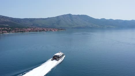 Aerial-View-Of-Catamaran-With-Backwash-On-Blue-Water-Of-Adriatic-Sea-Near-Korcula-Town-In-Croatia