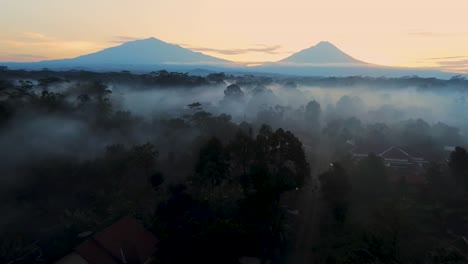 Magical-misty-morning-in-tropical-forest-of-Windusari,-Indonesia,-aerial-view