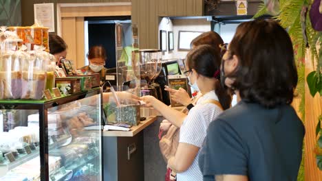 People-Wearing-Face-Mask-Buying-and-Waiting-For-Their-Orders-In-Coffee-Shop