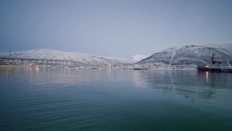 Beautiful-White-Hills-And-Tranquil-Waters-Of-Tromso-Harbor-In-Norway---wide-shot
