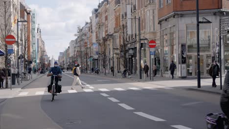 Maskierte-Menschen-Fahren-Fahrrad-Im-Stadtzentrum-Von-Leuven,-Belgien