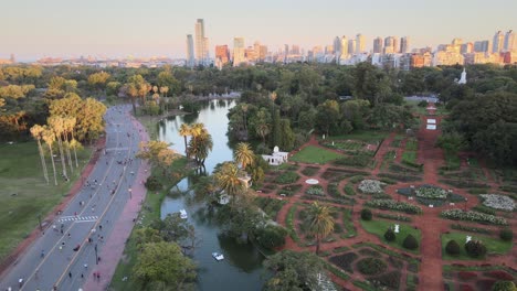 Aerial-lowering-over-Rosedal-gardens-near-pond-and-pedestrian-street-in-Palermo-neighborhood-at-sunset,-Buenos-Aires