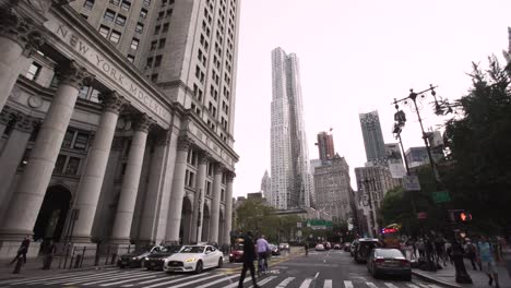 NYC:-Center-Street-facing-Spruce-Street-Tower,-Downtown-Manhattan-street-scene-with-cars-and-pedestrians---Gimbal-pull-backwards