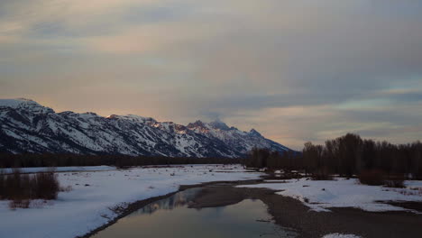 Grand-Teton-Mountains-Im-Nationalpark-Mit-Alpenglühen-Und-Schneebedecktem-Fluss-Mit-Reflexion-Vom-Eisigen-Fluss-In-Wyoming-Vereinigte-Staaten-Prores-4k