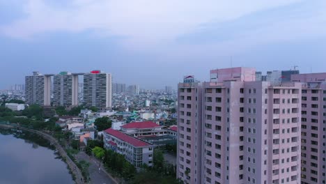 Schwenkdrohnenaufnahme-Von-Gebäuden,-Sonnenuntergang,-Brücke,-Kanal,-Reflexion-Und-Zersiedelung-Des-Bezirks-Acht-Von-Ho-Chi-Minh-Stadt
