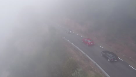 Vista-Aérea-Siguiendo-La-Parte-Trasera-Cercana-A-Los-Coches-Caros-De-Gama-Alta-Que-Conducen-Carreteras-De-Montaña-Sinuosas-Y-Sinuosas-En-Barcelona