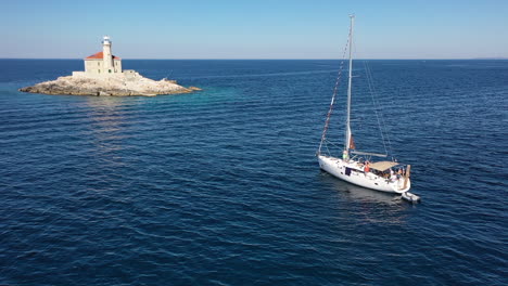 Aerial-View,-Mulo-Island-Lighthouse-and-Touristic-Boat-With-People-on-Sunny-Day-at-Adriatic-Sea,-Croatia,-Drone-Shot