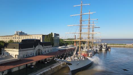 Aerial-of-ARA-Libertad-sailing-ship-parked-and-being-cleaned-in-Puerto-Madero-docks-at-daytime,-Buenos-Aires