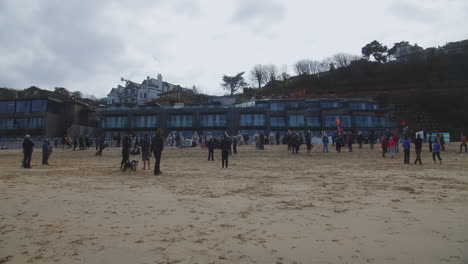 Random-people-protesting-on-the-beach-in-front-of-the-Carbis-Bay-Hotel-in-St-Ives,-Cornwall-whilst-socially-distancing