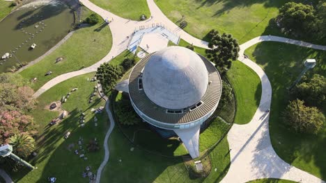 Descenso-Aéreo-En-El-Planetario-Galileo-Galilei-Entre-Caminos-En-Los-Bosques-De-Palermo-Durante-El-Día,-Buenos-Aires