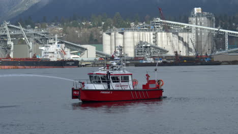 Puesto-De-Bombero-En-El-Barco-De-Bomberos-De-Vancouver-Mientras-Rocía-Agua-En-La-Entrada-De-Burrard-En-Vancouver,-Canadá