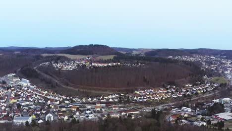 Aerial-view-of-the-recreation-area-of-the-Swabian-Alb-town-Albstadt,-flying-backwards-with-the-drone-to-reveal-the-beautiful-nature-at-the-winter-season-without-snow