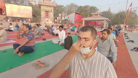 People-gather-at-Assi-Ghat-to-practice-group-yoga-organized-by-Subeh-Banaras-foundation-in-Varanasi,-India-on-09-March-2021