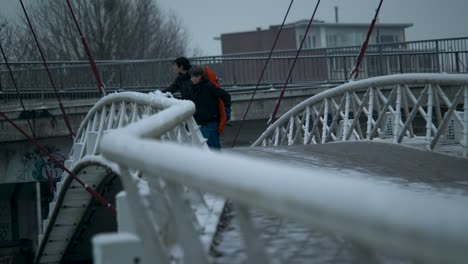 Boys-walk-over-urban-bridge-on-snowy-day-in-Belgium