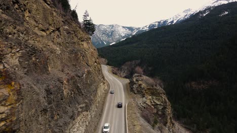 Aerial-drone-shot-of-cars-driving-on-Duffey-Lake-Road-in-British-Columbia,-Canada
