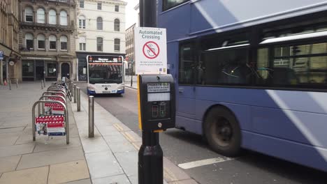 A-coronavirus-sign-on-a-pedestrian-crossing-as-two-buses-drive-past
