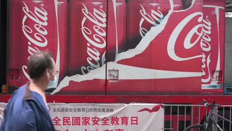 La-Gente-Pasa-Frente-Al-Logotipo-De-Coca-cola-De-La-Marca-Estadounidense-De-Refrescos-Que-Se-Muestra-En-Su-Camión-De-Reparto-De-Marca-En-Hong-Kong