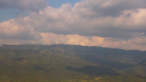 Timelapse-of-fluffy-clouds-rolling-over-mountain-valley-and-creating-shadow,-vintage-vibe
