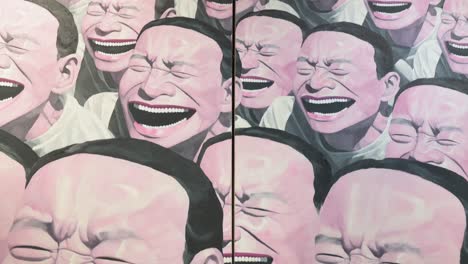 Chinese-artist-Yue-Minjun-art-piece-named-"Self-portrait",-depicting-himself-while-grinning-with-his-mouth-gaping,-at-the-world's-largest-brokers-modern-collectibles-Sotheby's-show-in-Hong-Kong