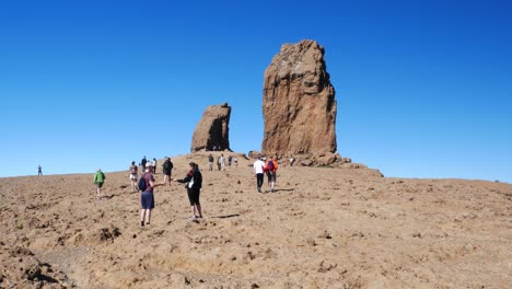 Tilt-up-over-Tourists-visiting-"Roque-Nublo",-Gran-Canaria