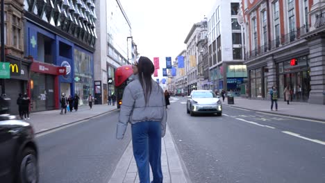 Girl-walking-in-middle-of-street-while-traffic-passes-on-both-sides-of-her