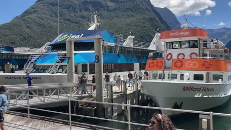 Pasajeros-De-Un-Tour-Que-Llegan-Al-Puerto-De-Milford-Sound-Mientras-Otros-Esperan-Para-Embarcar-En-Un-Crucero-En-Fiordland,-Nueva-Zelanda