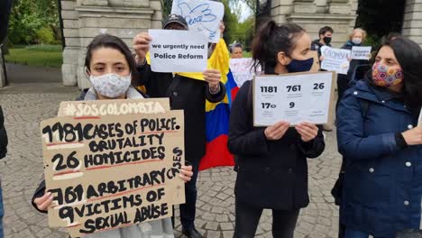 Handheld-video-of-a-Colombian-protest-in-Ireland,-people-with-protest-billboards