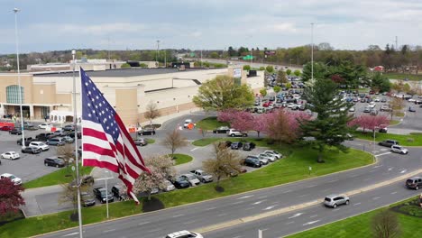 Aerial-of-American-USA-flag-flying-at-large-shopping-mall