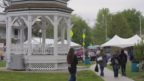 People-walk-on-promenade-next-to-gazebo,-Dogwood-Festival,-Siloam-Springs,-AR