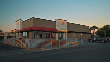 Customer-walks-out-of-McDonald's-restaurant-at-dusk