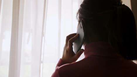 Silhouette-of-young-Asian-woman-answering-her-cell-phone