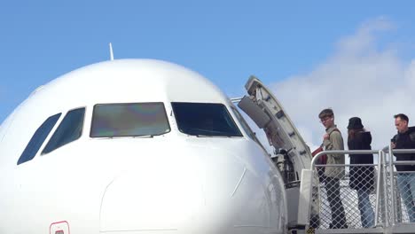 Footage-of-airport-passengers-boarding-into-the-commercial-aircraft-airplane-by-climbing-the-movable-stairs