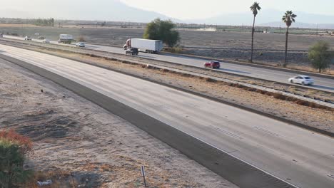 Autos-Und-Lastwagen-Fahren-Auf-Der-Autobahn-Interstate-10-Inmitten-Der-Trockenen-Landschaft-Kaliforniens