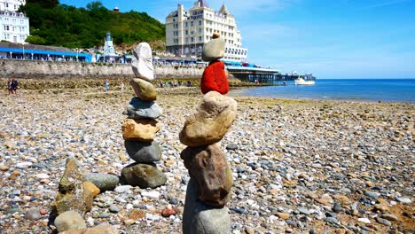 Bunte-Felsen-Anordnung-Balanciert-Am-Sonnigen-Llandudno-Strand-Küstenlinie-Dolly-Rechts