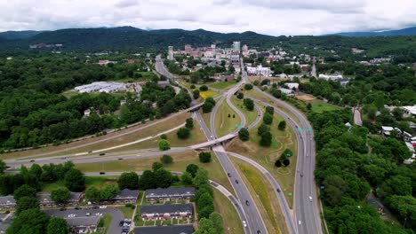 Aerial-push-into-Asheville-NC-Skyline,-Asheville-North-Carolina-with-Traffic-in-foreground