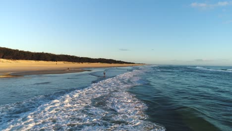 Luftaufnahme-Des-Menschen-Beim-Angeln-Am-Strandufer-Mit-Einem-Wunderschönen-Sonnenaufgang,-Der-Sich-Am-Meer-An-Der-Nehrung-In-Southport-Gold-Coast-Qld,-Australien,-Widerspiegelt
