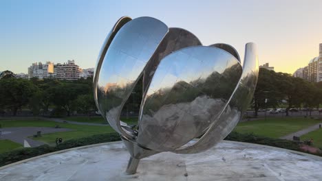 Aerial-close-up-orbiting-shot-capturing-details-metallic-reflection-of-floralis-generica,-art-installaition-symbolised-reborn,-at-sunset-golden-hours-in-Buenos-Aires-capital-city-of-Argentina