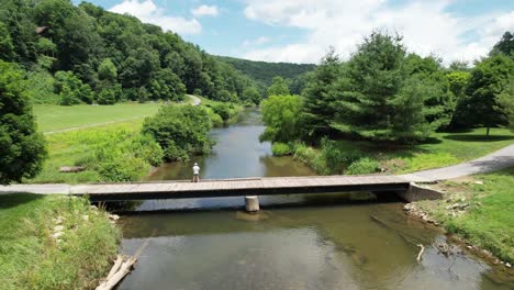 Woman-fishes-off-bridge-on-New-River-near-Boone-NC,-North-Carolina-in-Watauga-County-NC,-North-Carolina