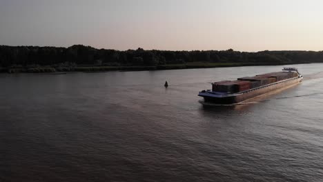 Aerial-View-Of-Port-And-Bow-Side-Of-Devotion-Cargo-Ship-In-Travelling-Along-Oude-Maas-In-Early-Evening